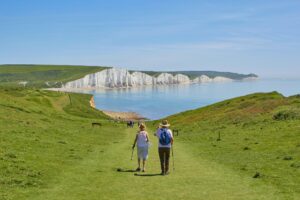 Exterior, an elderly couple on a luscious countryside hike, for “How High-Earning Professionals Can Put Their Bonus to Work with the Note D”